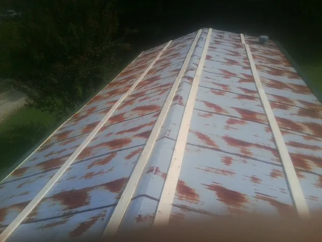 Rusted metal roof panels with new wood purlins before replacement — Storm Damage Roof Repair in Loris by Roofing Brothers