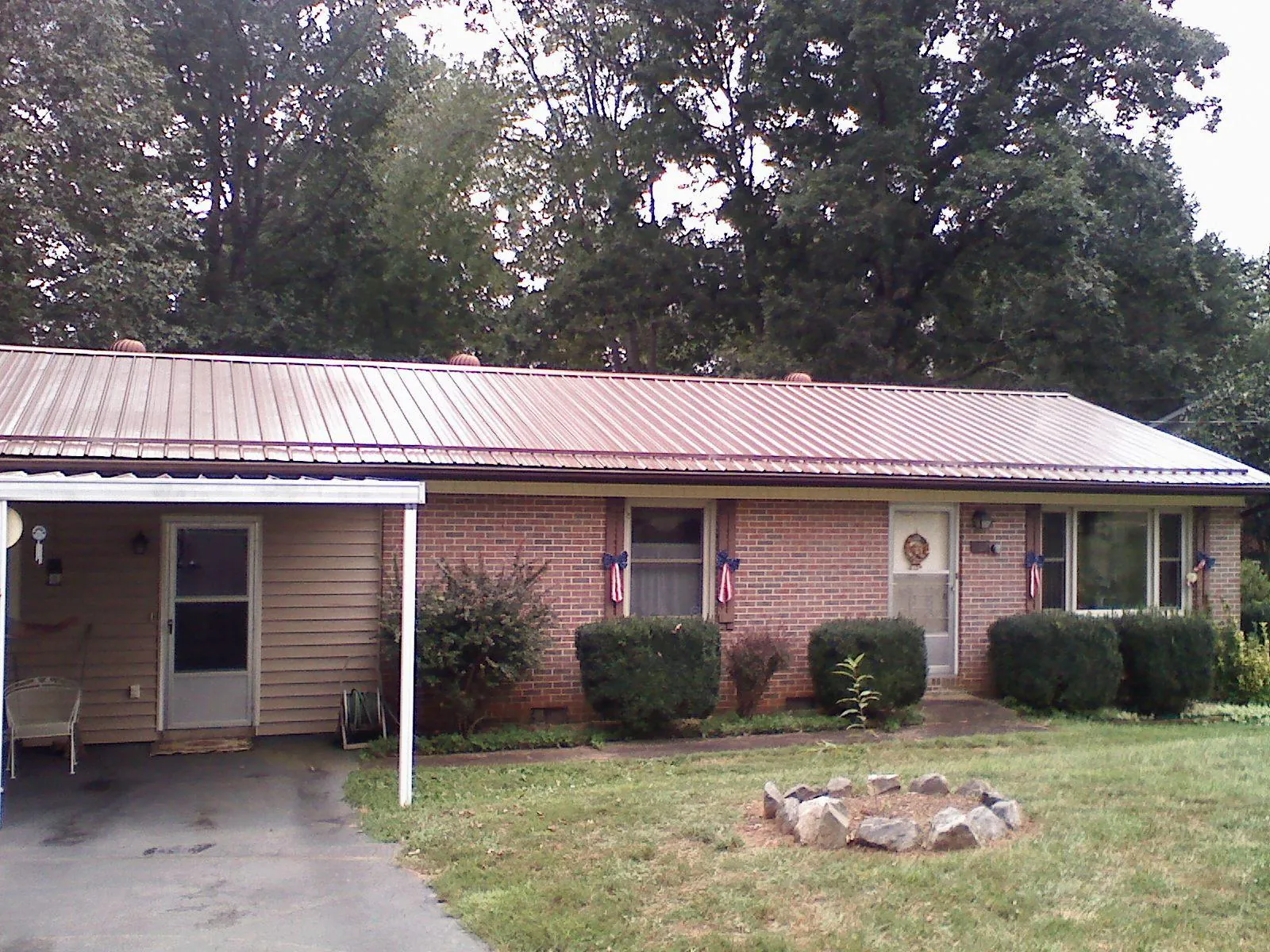 Bronze metal roof and carport on a brick ranch home — Roof Repair work by our crew in Loris